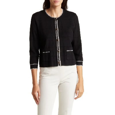 A woman wearing a black blazer and white pants