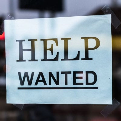 blue sign in window reads HELP WANTED