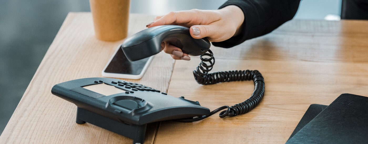 cropped photo of businesswoman picking up phone handset