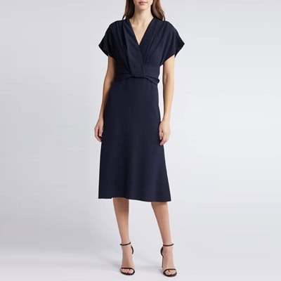 A woman wearing a navy dress and navy heels