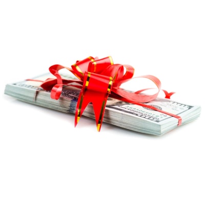 a pile of cash has a red ribbon around it, tied in a big bow