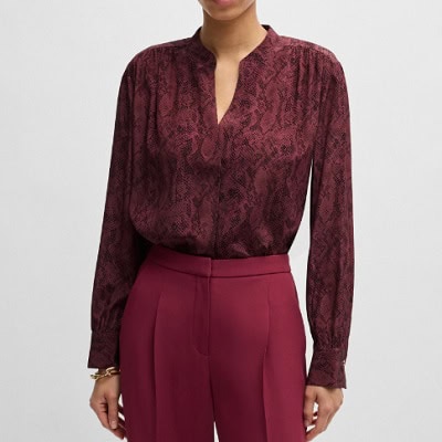 A woman wearing a maroon long sleeve top and maroon pants