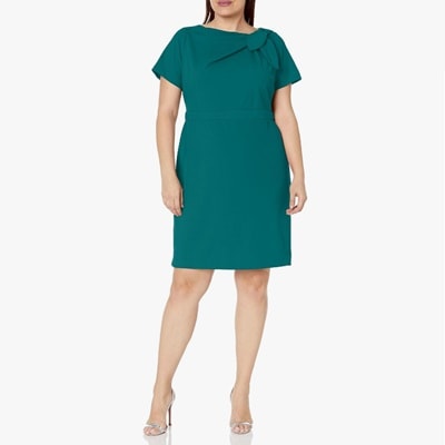 A woman wearing a green dress and silver sandals