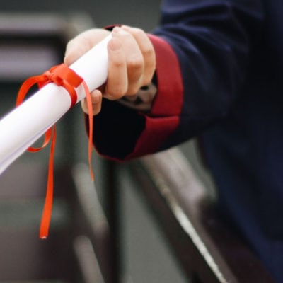 woman receiving MBA degree bound with red ribbon