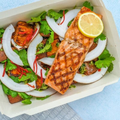 salmon over salad in a takeout container