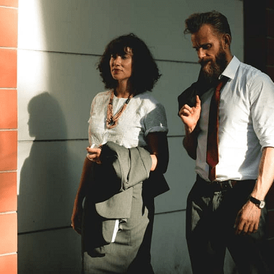 man and woman walking; they are both carrying the blazer to their business suit