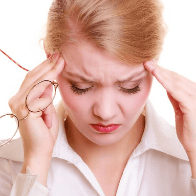blond woman rubbing her temples and holding her eyeglasses