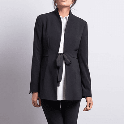 A woman wearing a black maternity blazer with black pants and a white blouse